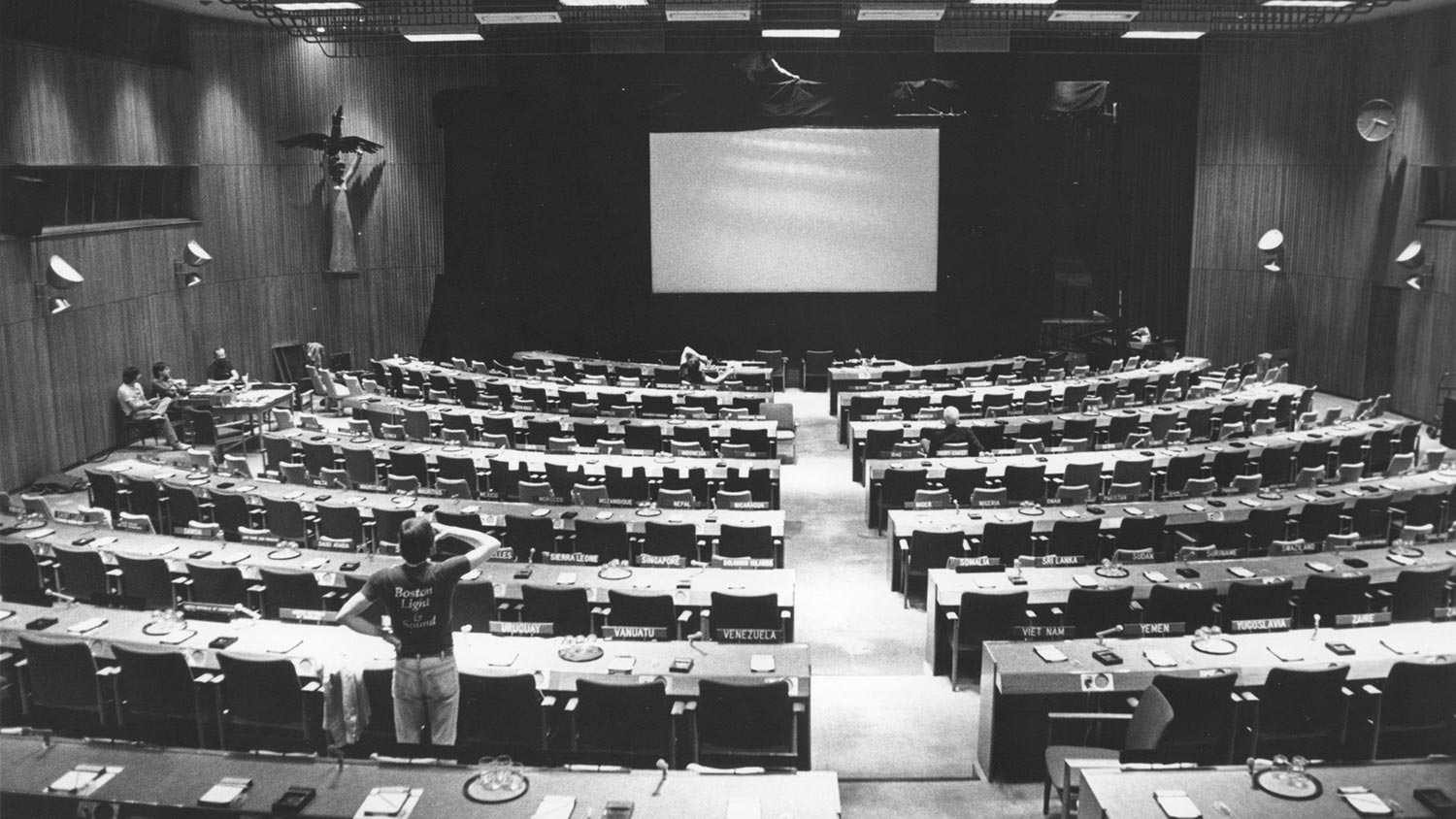 Large conference room with empty seats and a blank screen at the front