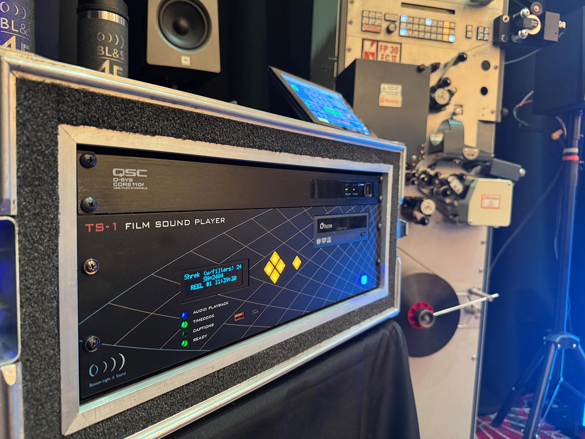 Audio player equipment mounted in a rack case next to a film projector