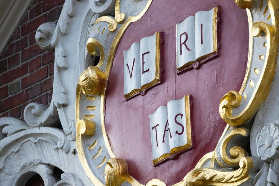 Close-up of Harvard University emblem with the word Veritas on books