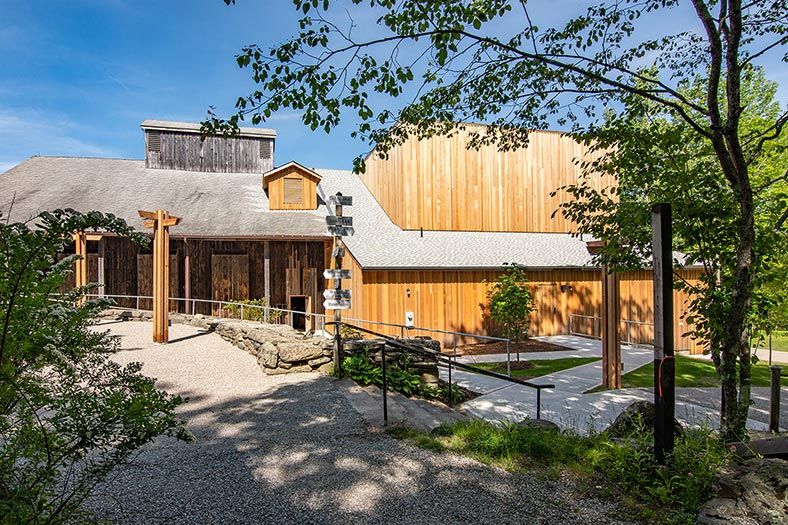 Back view of a large wooden auditorium with blue seats and timber-framed ceiling