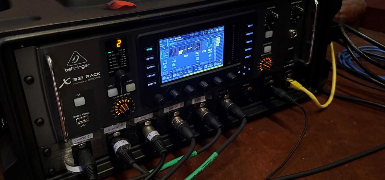 Digital audio mixer with various input cables and a touchscreen interface