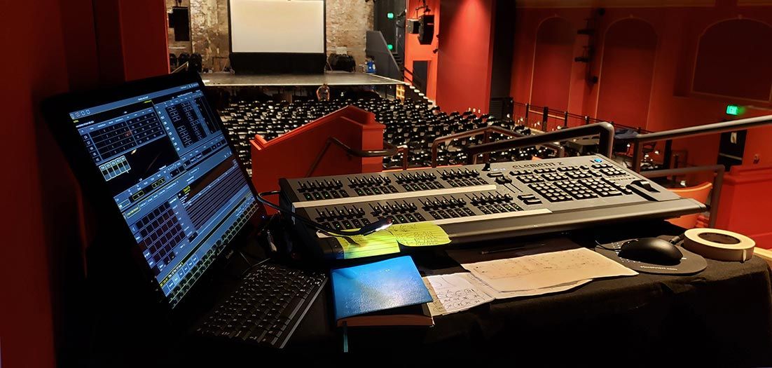 View from the balcony of a red-walled theater with stage setup