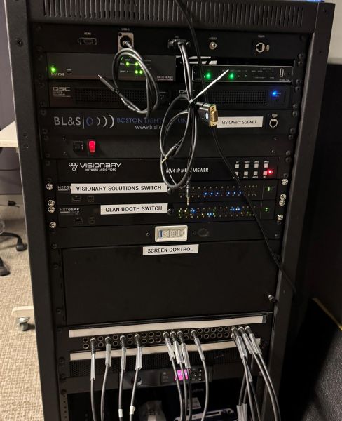 Close-up of AV rack with labeled switches and numerous connected cables