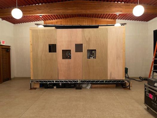 Projection booth with three viewing windows built from light wood panels