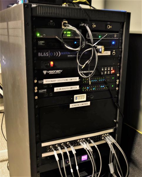 AV equipment rack with various switches and control units labeled for audio and video